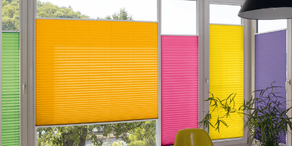 Fenêtres avec stores plissés colorés dans un intérieur lumineux